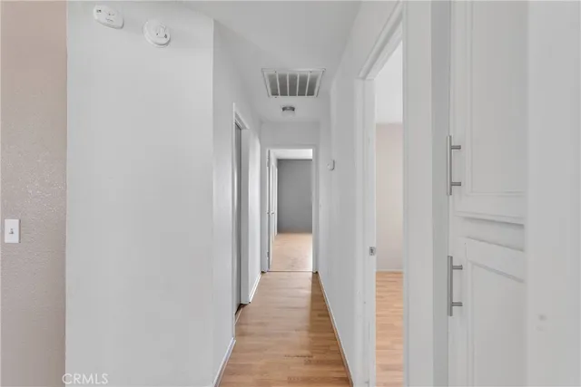 a view of a hallway with wooden floor