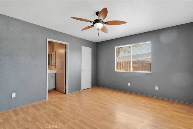 a view of an empty room with a ceiling fan and a window