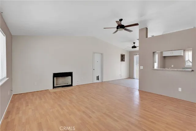 a view of a big room with wooden floor and windows