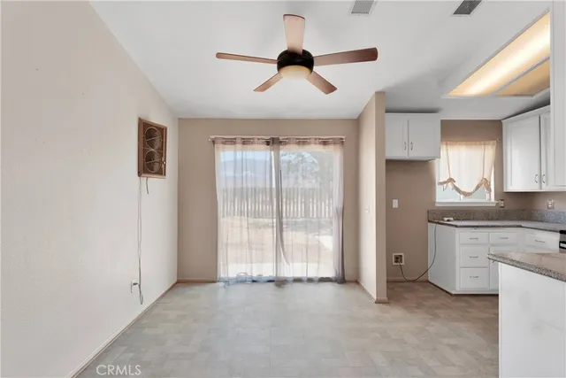a view of an empty room with window and cabinet