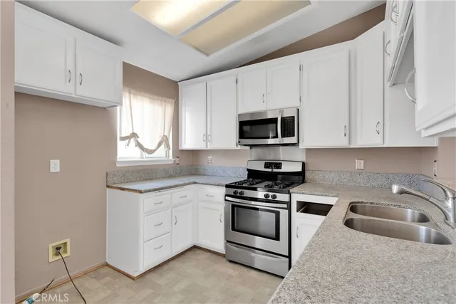 a kitchen with white cabinets stainless steel appliances and sink