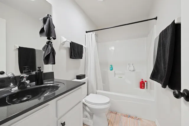 a bathroom with a sink vanity mirror and toilet