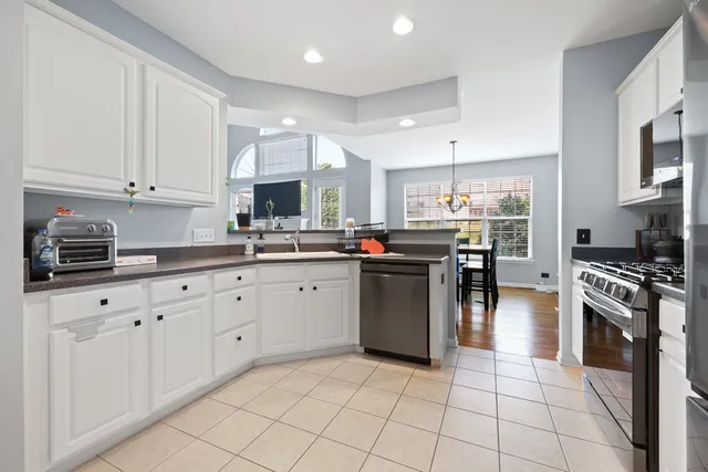 a kitchen with kitchen island granite countertop a stove sink and cabinets