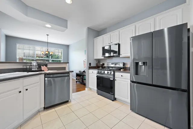 a kitchen with granite countertop a refrigerator and a sink