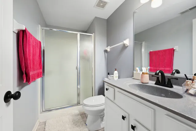 a bathroom with a granite countertop sink mirror vanity and toilet