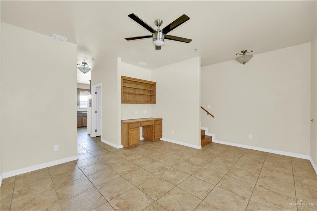 1814 East Iowa Road Edinburg, TX 78542 - Photo 2 of 22 an empty room with a ceiling fan and windows