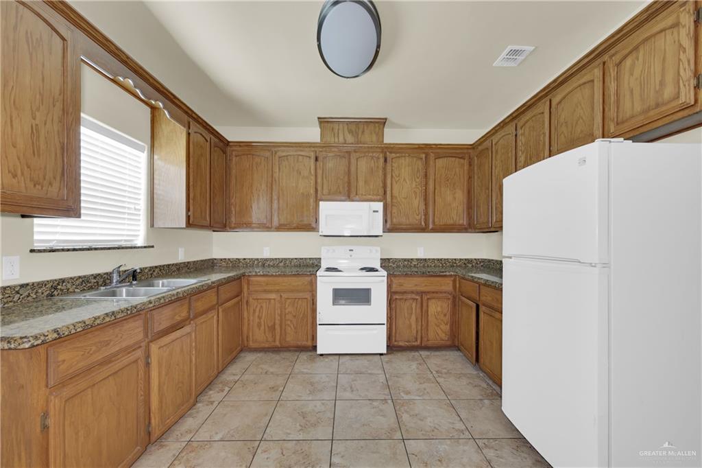 1814 East Iowa Road Edinburg, TX 78542 - Photo 8 of 22 a kitchen with a stove a refrigerator and a sink