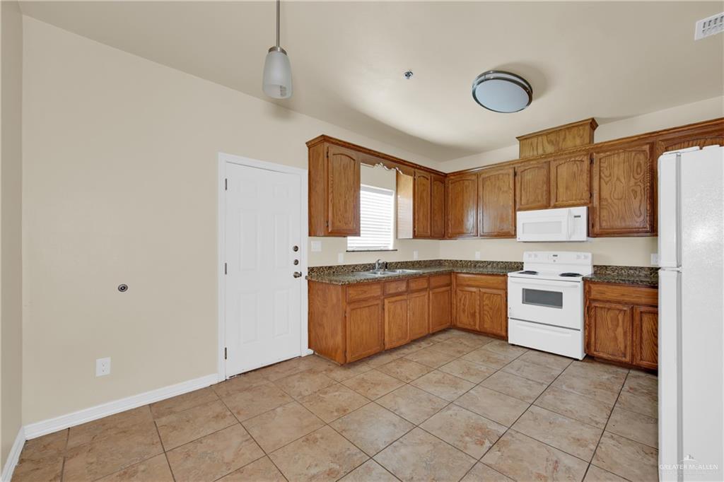 1814 East Iowa Road Edinburg, TX 78542 - Photo 9 of 22 a large kitchen with stainless steel appliances granite countertop a stove sink and cabinets