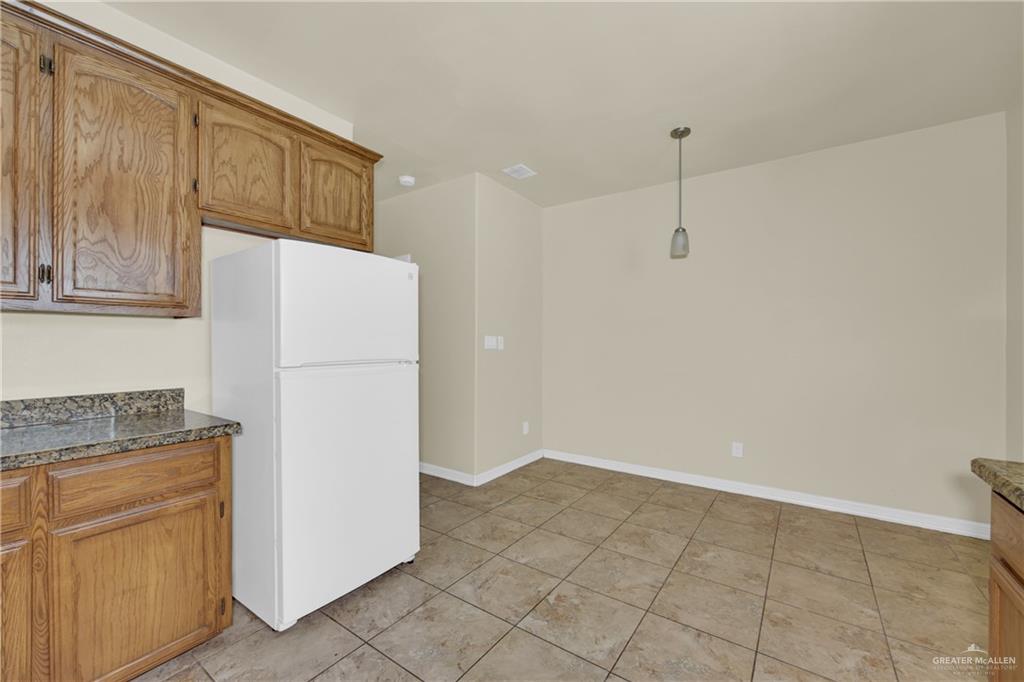 1814 East Iowa Road Edinburg, TX 78542 - Photo 10 of 22 a kitchen with a refrigerator a stove top oven and cabinets