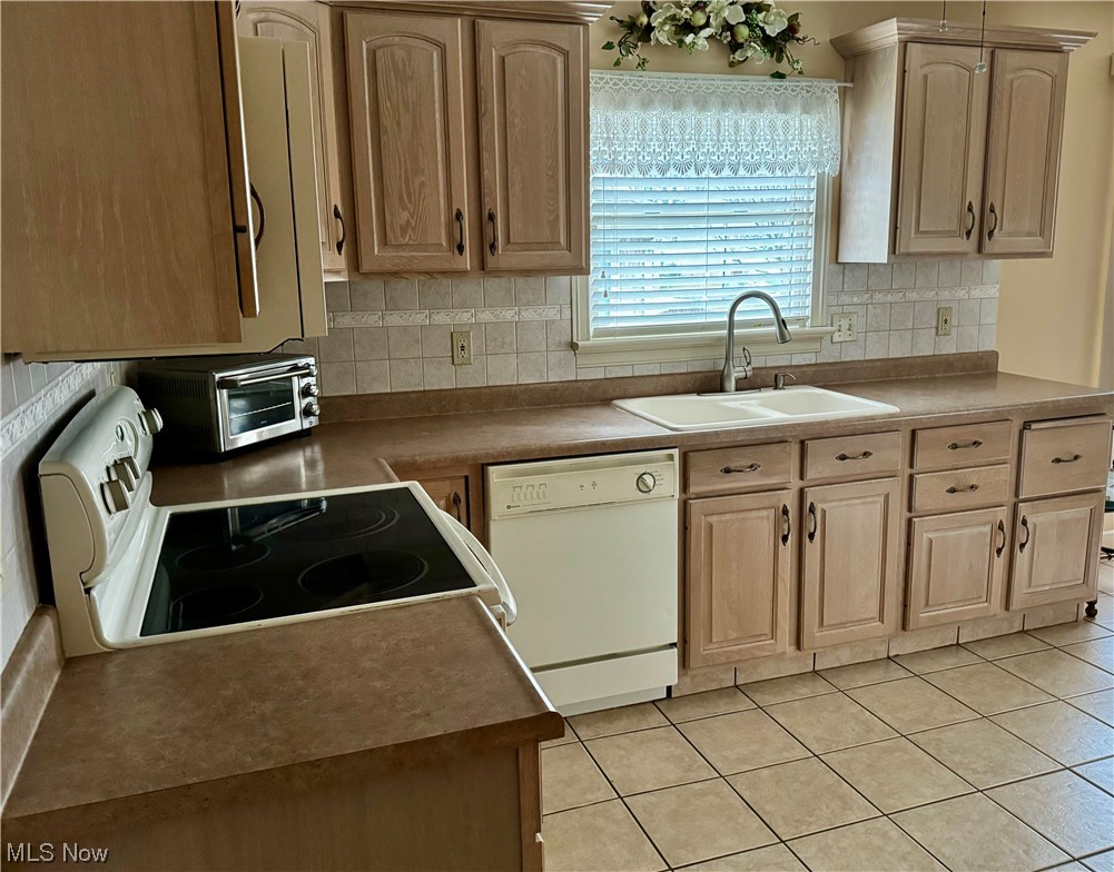 183 Mathews Road, Unit A Youngstown, OH 44512 - Photo 7 of 32 Kitchen featuring light tile floors, tasteful backsplash, white dishwasher, range, and sink