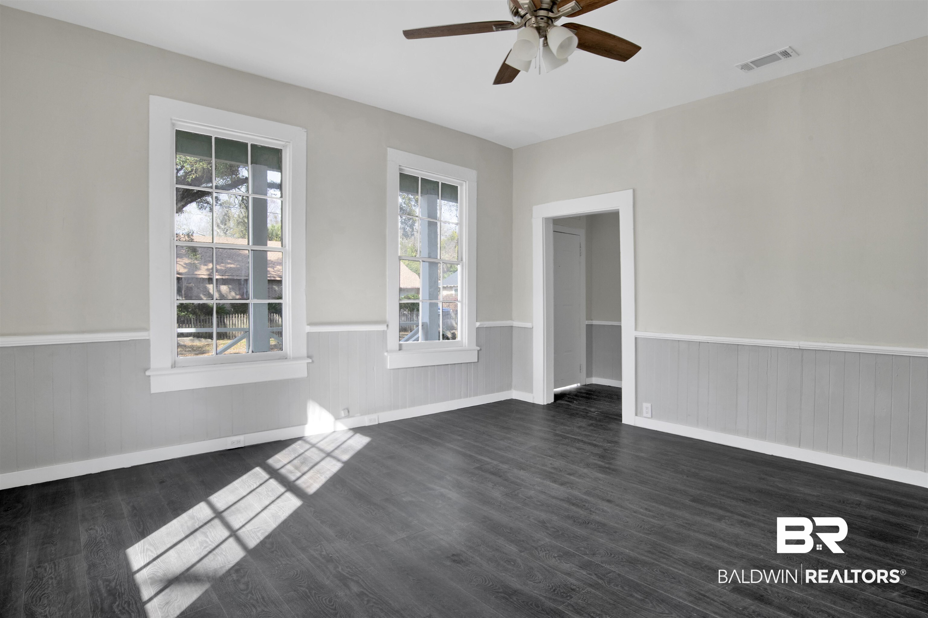1063 Selma Street Mobile, AL 36604 - Photo 6 of 32 Unfurnished room with ceiling fan, wainscoting, and dark wood finished floors