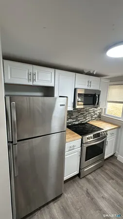 a kitchen with a stove a refrigerator and a microwave