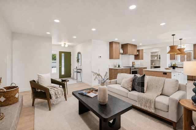 1168 East Center Street Bountiful, UT 84010 - Photo 4 of 38 Open-concept living space featuring wood-finish flooring, recessed lighting, a modern kitchen with wood-tone cabinetry, and a central island with white countertops