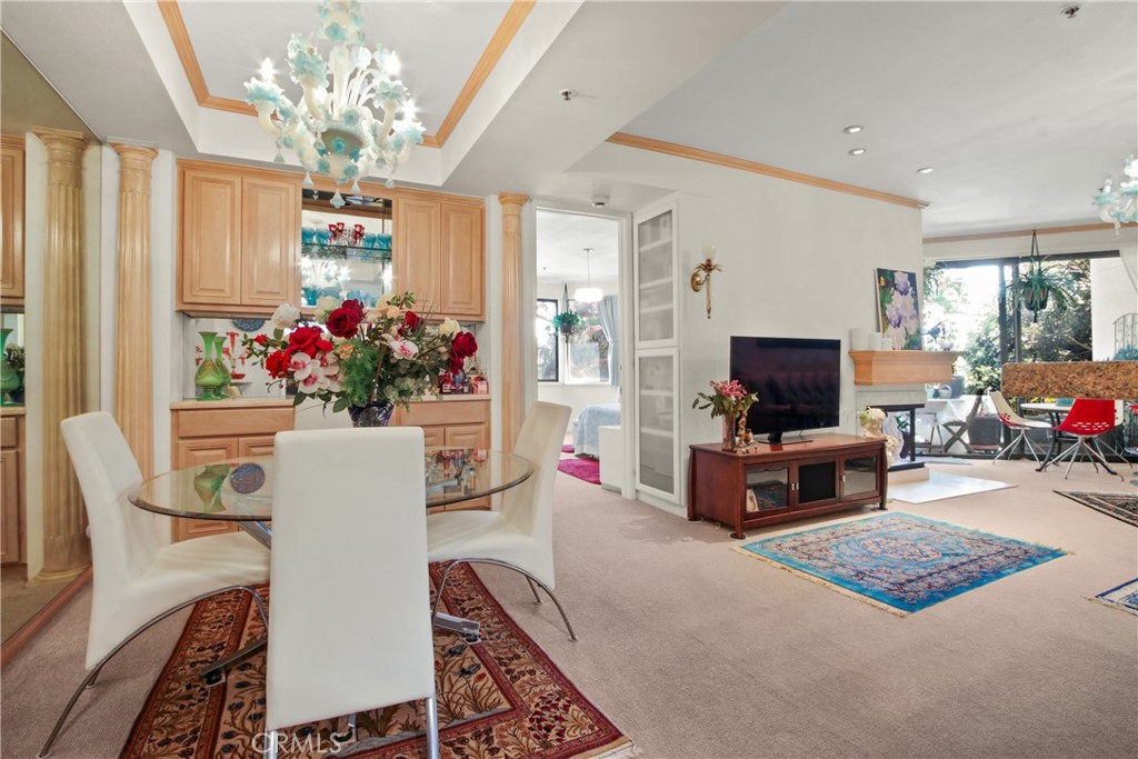 a living room with furniture a flat screen tv and a chandelier