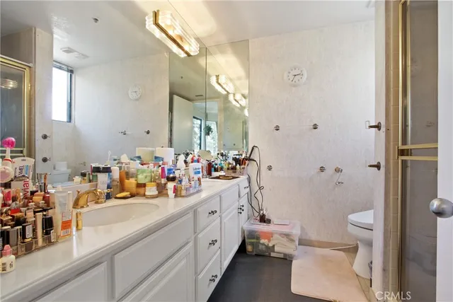 a bathroom with a double vanity sink toilet mirror and shower