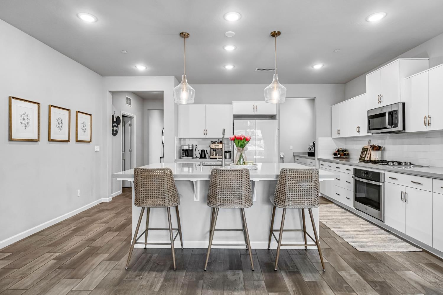 968 Pinnacle Drive Madera, CA 93636 - Photo 17 of 39 a kitchen with stainless steel appliances kitchen island granite countertop a stove a sink a refrigerator and a dining table with wooden floor
