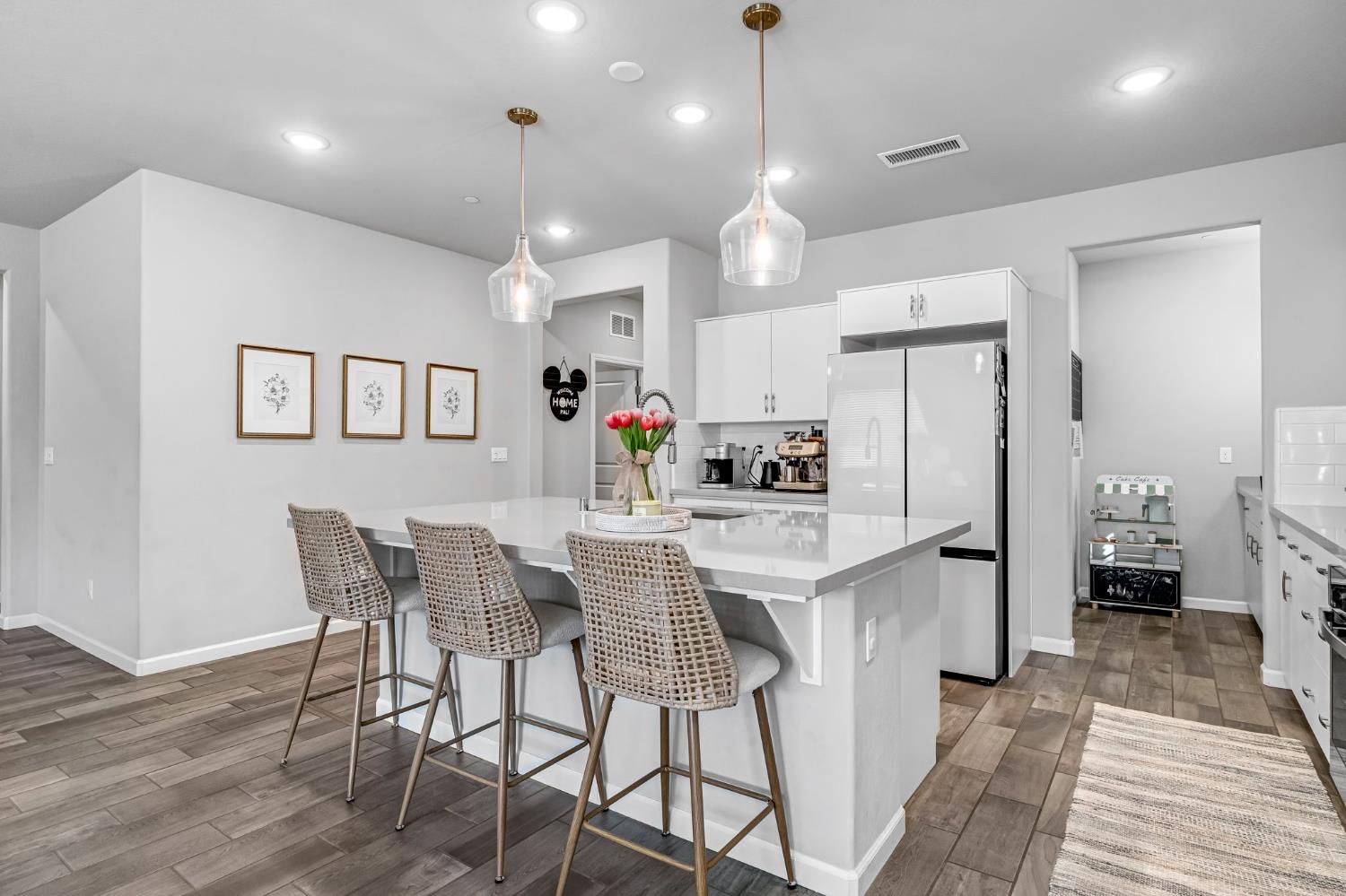 968 Pinnacle Drive Madera, CA 93636 - Photo 19 of 39 a kitchen with stainless steel appliances kitchen island granite countertop a dining table chairs and white cabinets