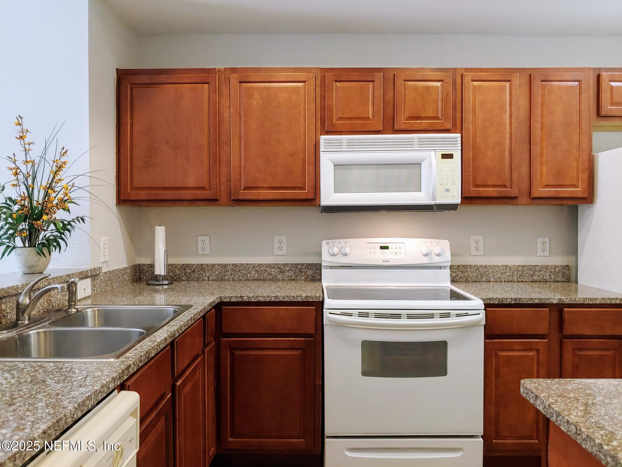 10200 Belle Rive Boulevard, Unit 3605 Jacksonville, FL 32256 - Photo 11 of 34 a kitchen with granite countertop cabinets stainless steel appliances and a sink