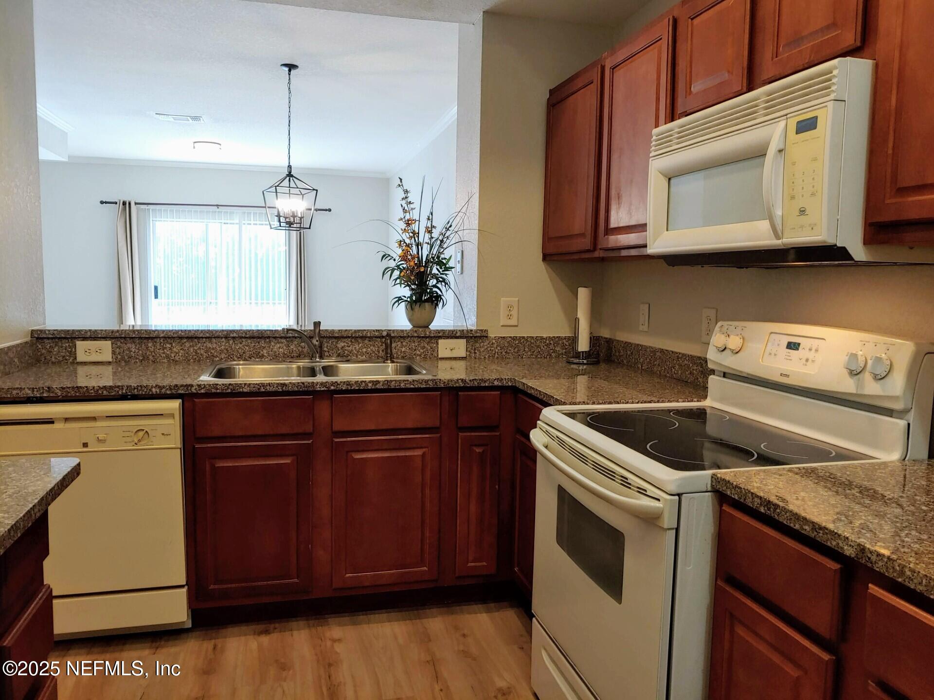 10200 Belle Rive Boulevard, Unit 3605 Jacksonville, FL 32256 - Photo 13 of 34 a kitchen with granite countertop stainless steel appliances a stove microwave and oven