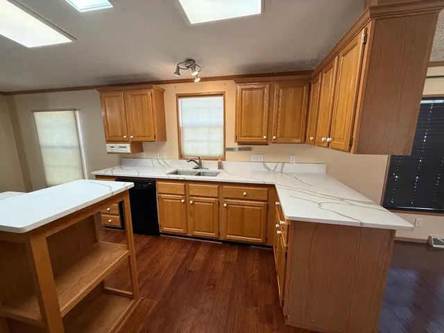 a kitchen with a sink a stove a counter space and a window