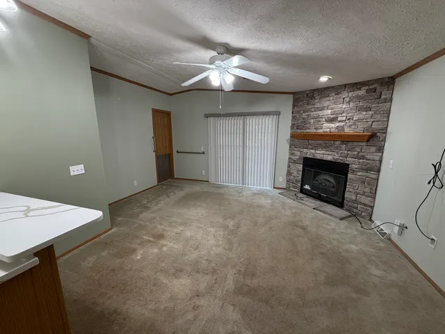 a view of an empty room with window and fireplace