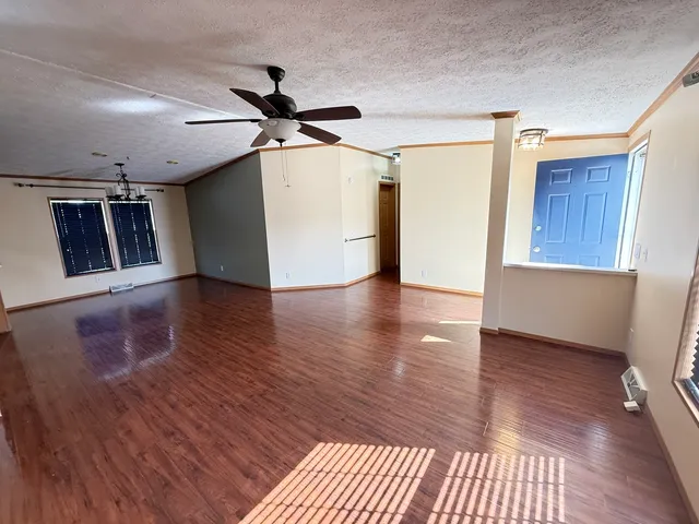 a view of a livingroom with wooden floor and a ceiling fan