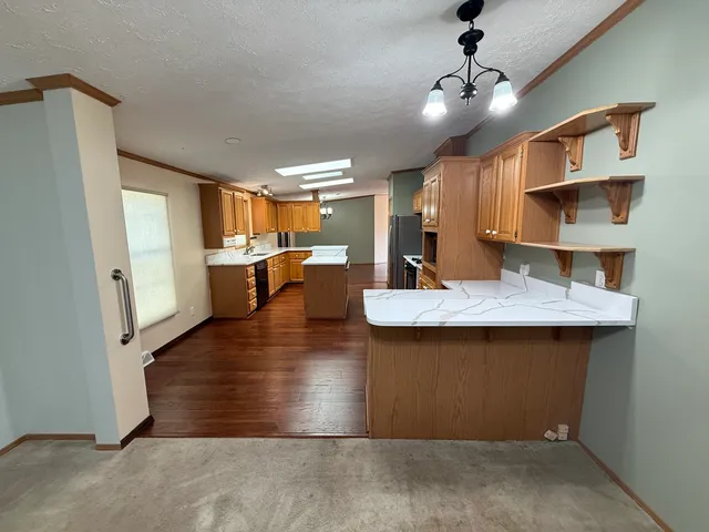 a kitchen with stainless steel appliances granite countertop a sink a stove and a refrigerator