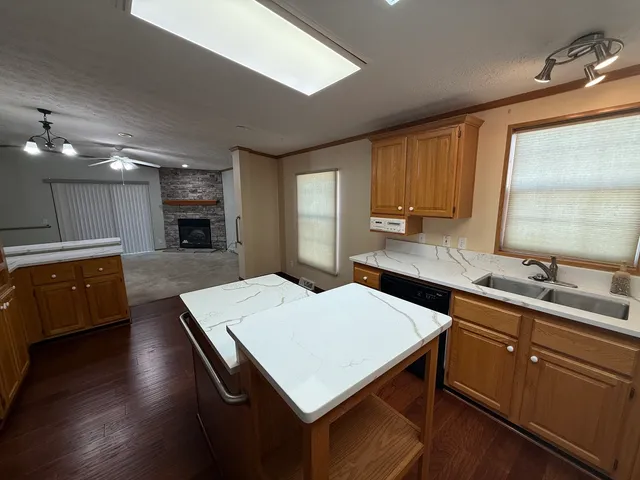 a kitchen with a stove a sink a microwave a center island and cabinets