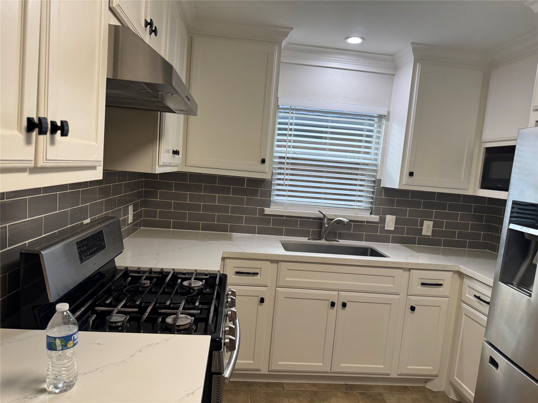 534 Sulphur Street Houston, TX 77034 - Photo 30 of 46 a kitchen with white cabinets a stove and a sink