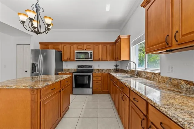 a spacious bedroom with a bed and a chandelier