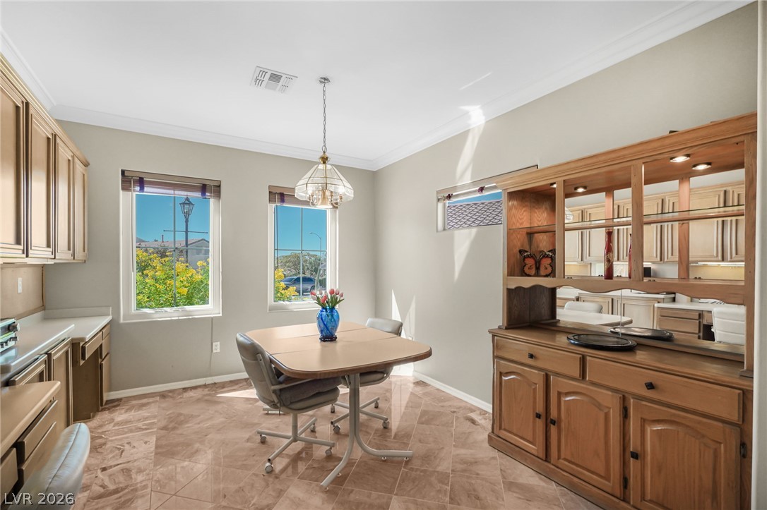 2738 Grand Forks Road Henderson, NV 89052 - Photo 12 of 52 Tile flooring and classic crown molding define this versatile dining space.