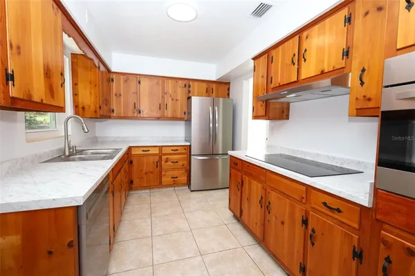a kitchen with stainless steel appliances granite countertop a sink and a refrigerator