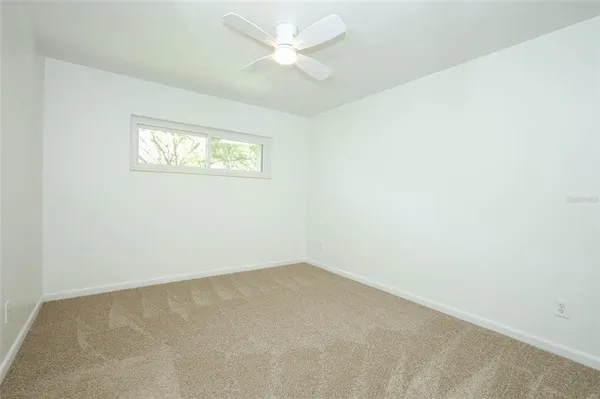 an empty room with an entryway and fan