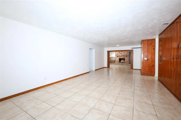 a view of an empty room and kitchen