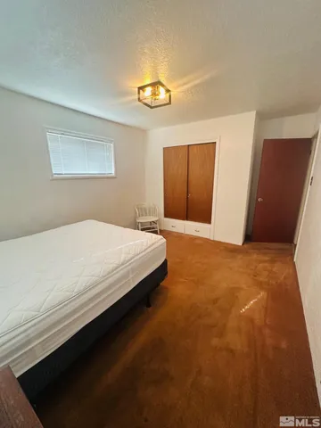 a spacious bedroom with a bed and a cabinet