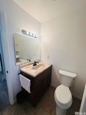 a bathroom with a granite countertop sink toilet and a mirror