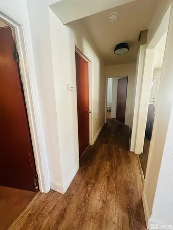 a view of a hallway with wooden floor and staircase