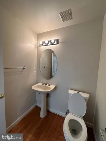a bathroom with a toilet a sink and mirror