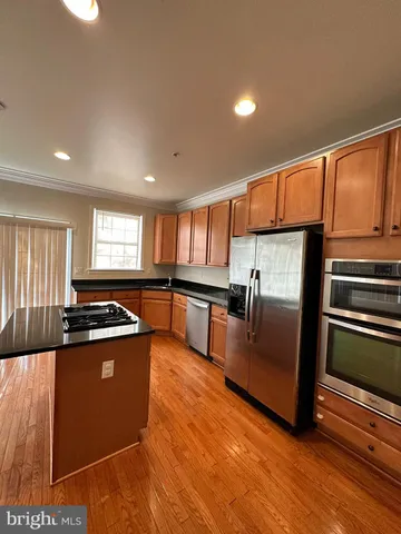 a kitchen with stainless steel appliances granite countertop a stove a sink and a refrigerator
