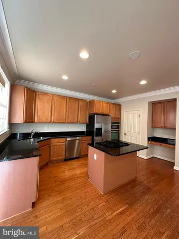 a kitchen with stainless steel appliances wooden cabinets and a counter top space
