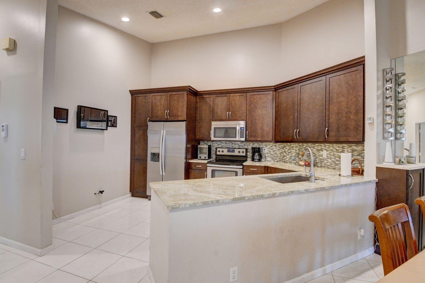 9238 Vineland Court, Unit G Boca Raton, FL 33496 - Photo 12 of 42 a kitchen with stainless steel appliances granite countertop a refrigerator and a sink