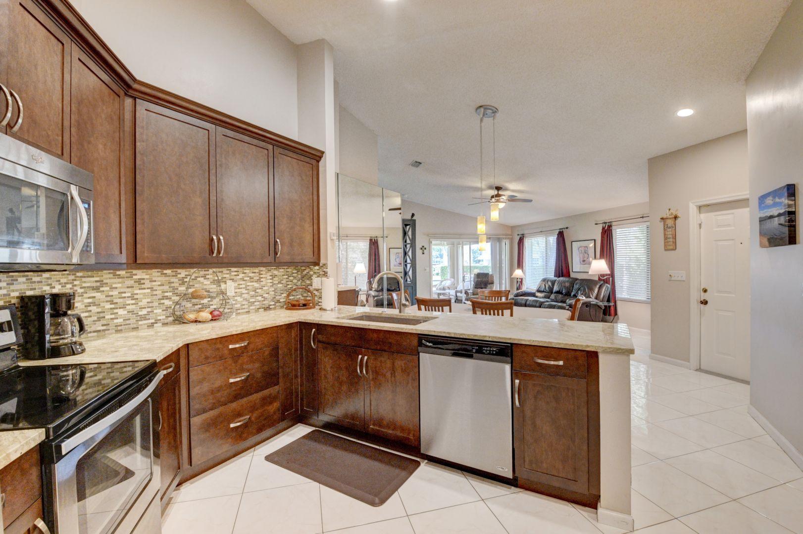 9238 Vineland Court, Unit G Boca Raton, FL 33496 - Photo 15 of 42 a kitchen with a sink a stove and cabinets