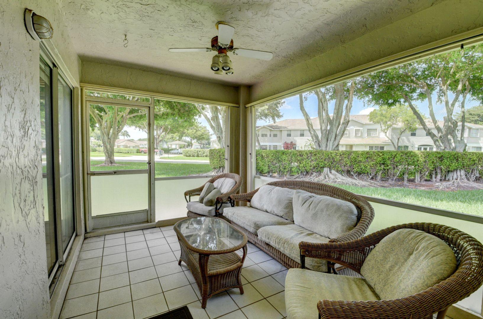 9238 Vineland Court, Unit G Boca Raton, FL 33496 - Photo 24 of 42 a living room with furniture and a floor to ceiling window