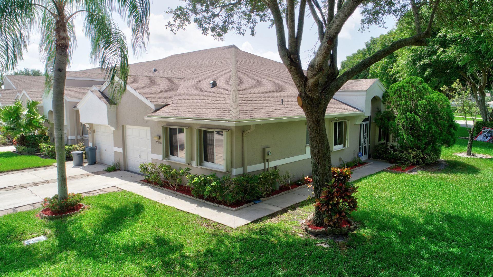 9238 Vineland Court, Unit G Boca Raton, FL 33496 - Photo 4 of 42 a front view of a house with a yard and porch