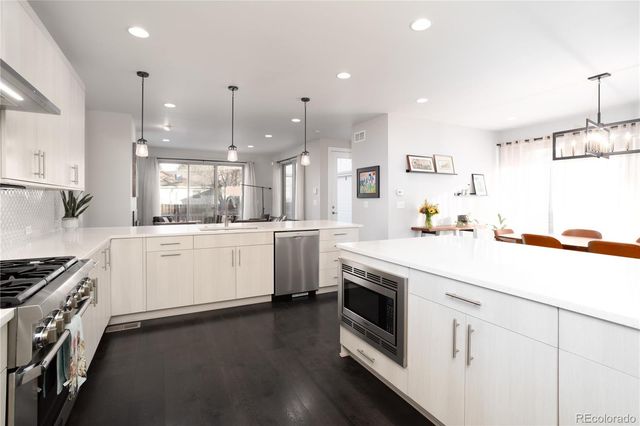 a kitchen with granite countertop white cabinets and white appliances