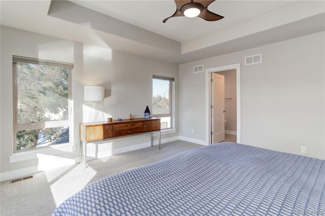 a view of a room with wooden floor and a ceiling fan