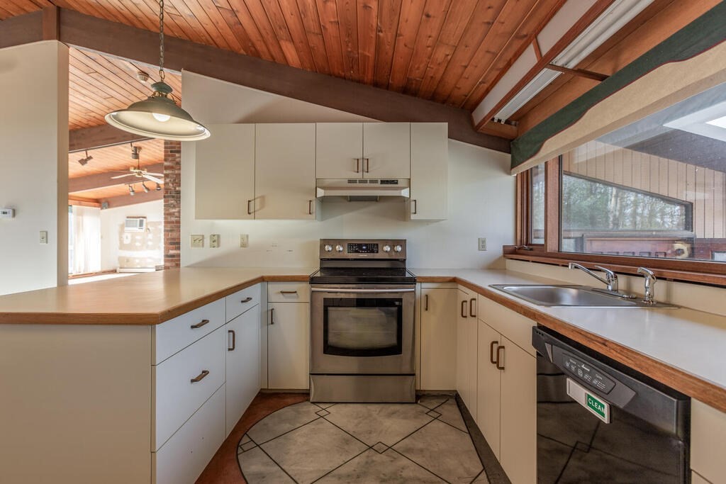 92 Leslie Road Rowley, MA 01969 - Photo 11 of 36 a kitchen with stainless steel appliances a sink cabinets and a window