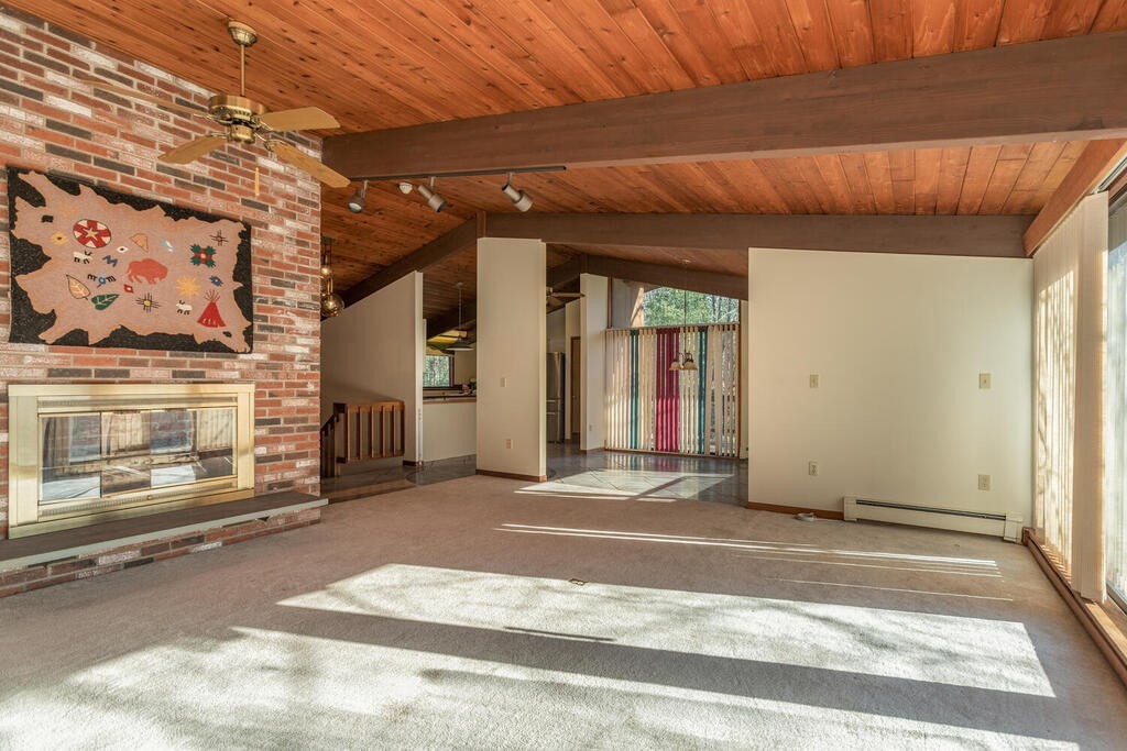 92 Leslie Road Rowley, MA 01969 - Photo 6 of 36 a view of a room with a fireplace and a ceiling fan