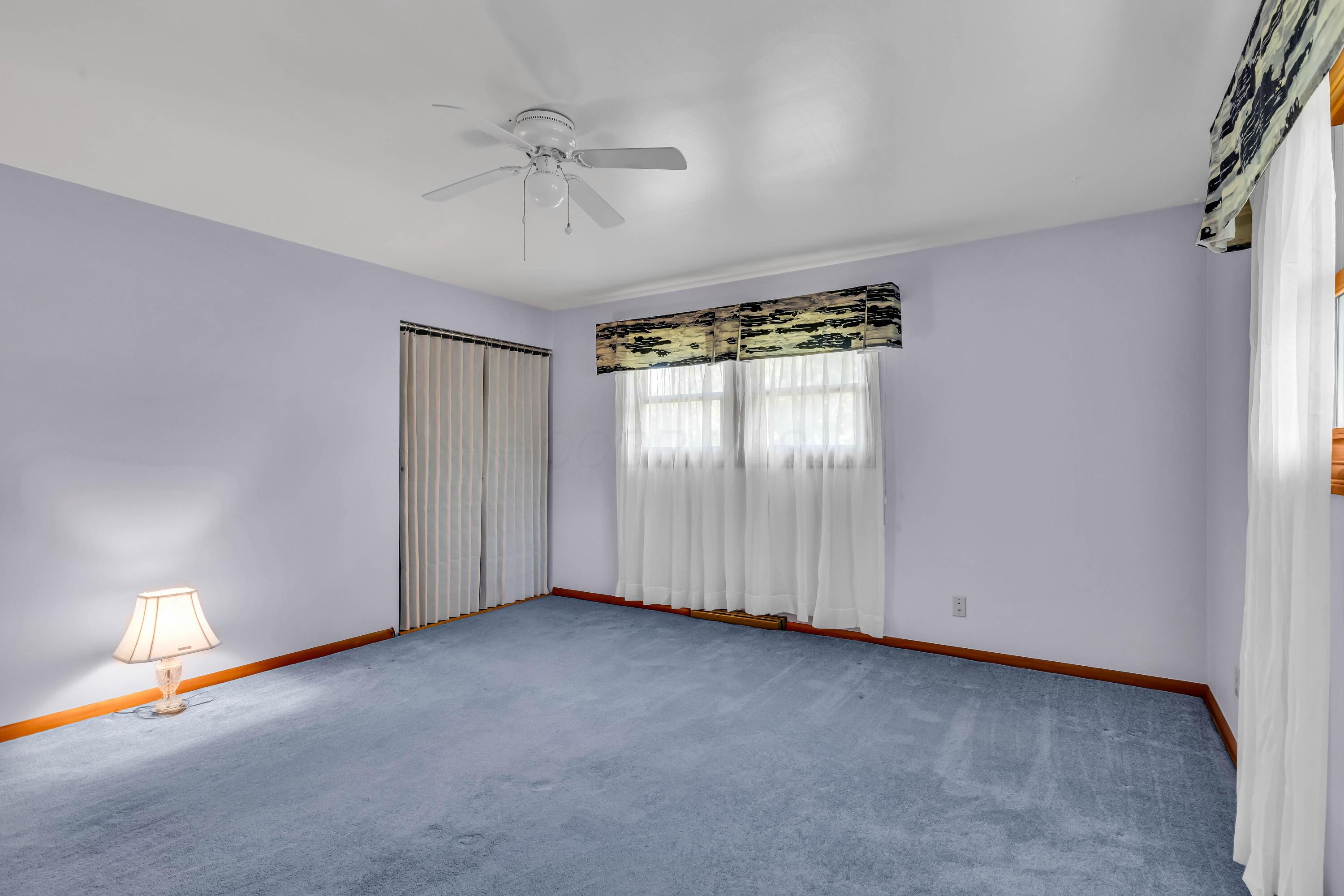 1213 East Cooke Road Columbus, OH 43224 - Photo 30 of 57 • Blue carpet • Hardwood flooring under carpet • Blue painted walls • Lighted ceiling fan • Lighted closet