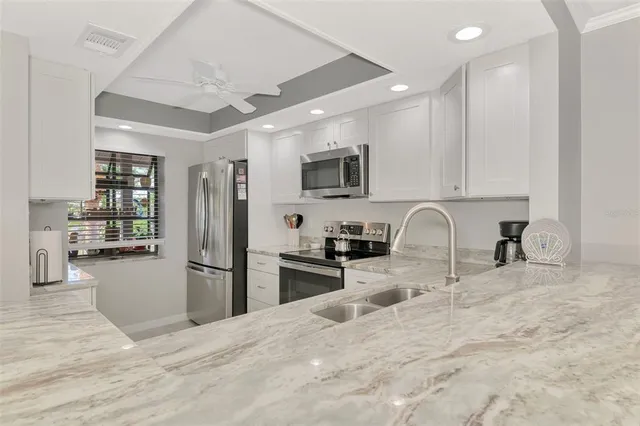 a kitchen with stainless steel appliances granite countertop a refrigerator sink and stove